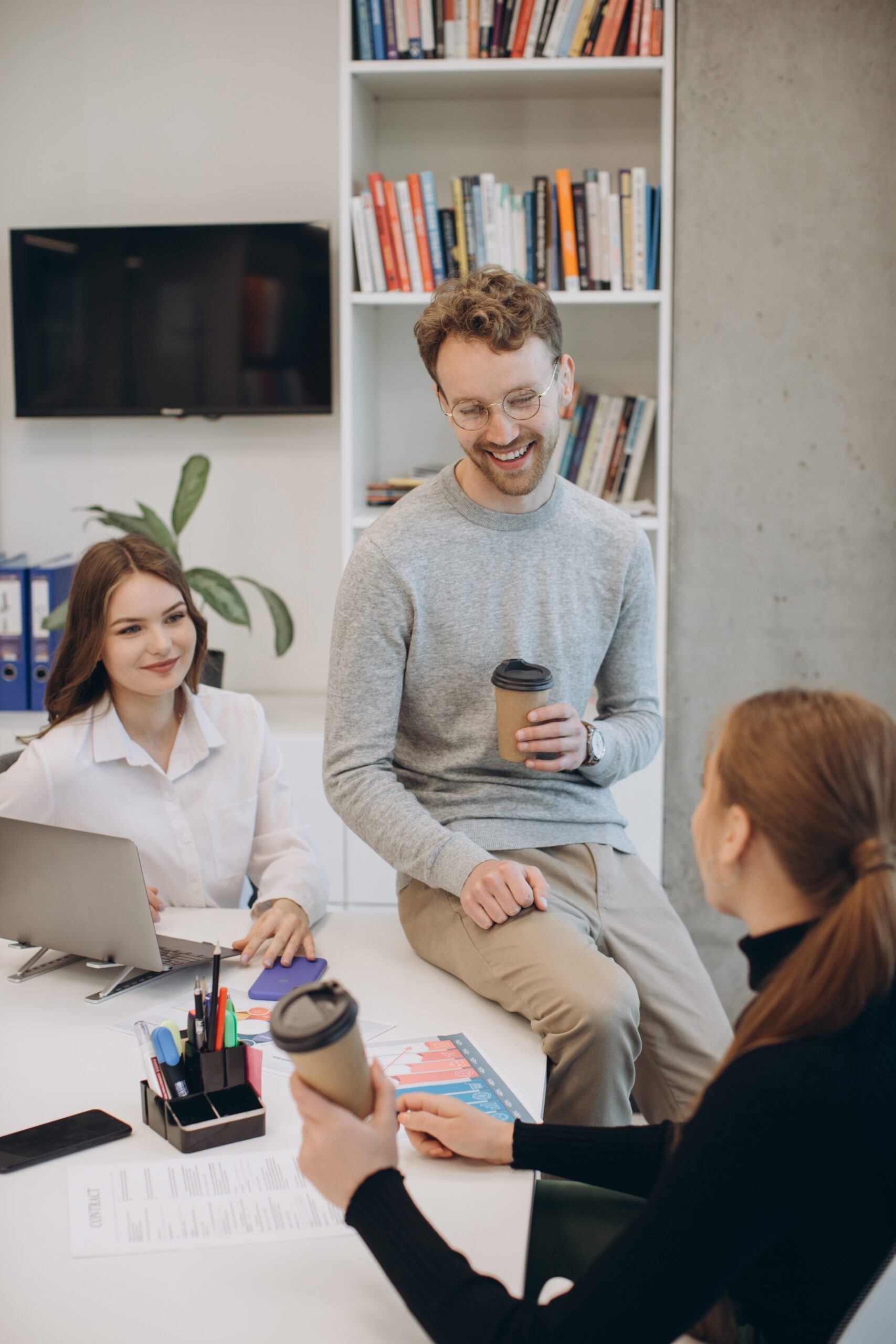 3 jeunes collègues souriants, dans leur bureau lors d'une pause café